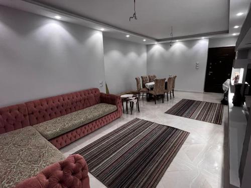 sala de estar con sofá rojo y mesa en Luxury apartments in Heliopolis, en El Cairo