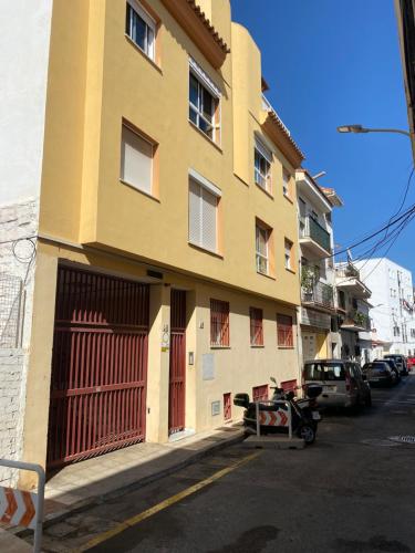 um edifício amarelo no lado de uma rua em TORREMOLINOS CENTRO - Beautiful , newly renovated 2 bedroom apartment em Torremolinos