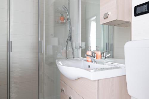 bagno bianco con lavandino e doccia di Casa San Giacomo - YourPlace Abruzzo a Rocca San Giovanni