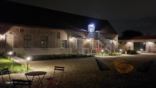 a brick building with a clock tower at night at B&B 't Meesterhof in Deinze
