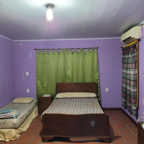 ein Schlafzimmer mit 2 Betten und einem grünen Vorhang in der Unterkunft Pequinos in Strobel