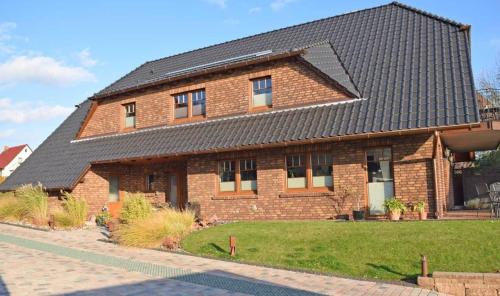 ein Backsteinhaus mit schwarzem Dach in der Unterkunft Ferienwohnung in Sellin mit Grill, Terrasse und Garten in Ostseebad Sellin