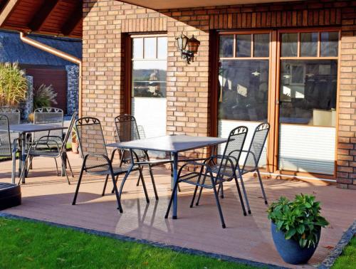eine Terrasse mit Tischen und Stühlen auf einer Terrasse in der Unterkunft Ferienwohnung in Sellin mit Grill, Terrasse und Garten in Ostseebad Sellin