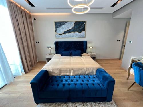 a blue couch in a bedroom with a bed at Enjoy Luxury Condo with Sea View in Abu Dhabi