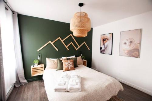 um quarto com uma cama grande e uma parede em tons de verde em L'Everest Ski, Rando & Vélo Mont Sainte-Anne em Beaupré