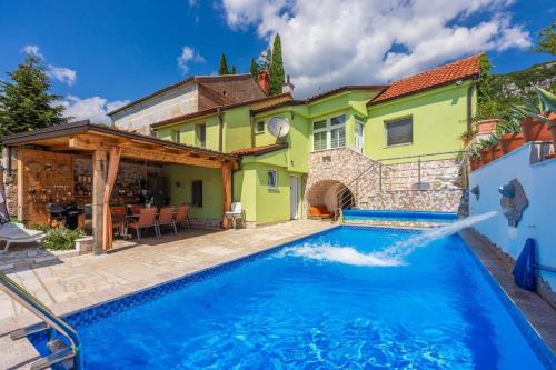 uma casa com piscina em frente a uma casa em Ferienhaus mit zwei Küchen, Garten, großer Terrasse und Swimmingpool em Bribir