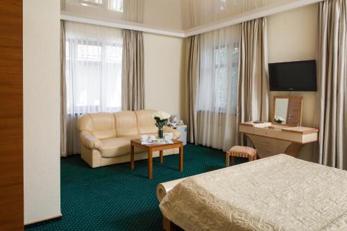 a hotel room with a bed and a couch and a table at Residence Odesskij Dvorik in Odesa