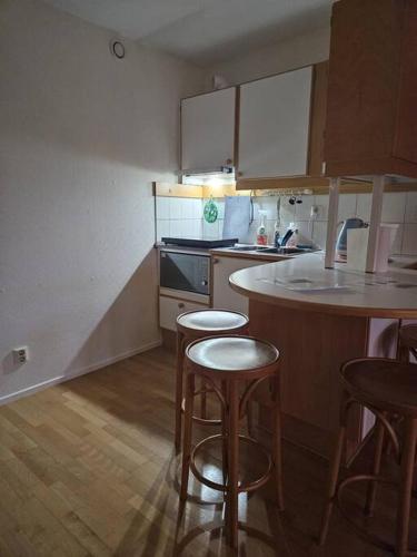 a kitchen with two bar stools and a counter top at Lägenhet i Älvsborg Göteborg in Gothenburg