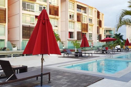 a red umbrella sitting next to a swimming pool at Nuevo Vallarta Condo 2Bed 2Bath in Nuevo Vallarta