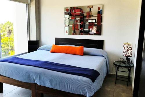a bedroom with a bed with an orange pillow on it at Nuevo Vallarta Condo 2Bed 2Bath in Nuevo Vallarta 