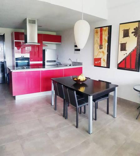 a kitchen with a black table and red cabinets at Nuevo Vallarta Condo 2Bed 2Bath in Nuevo Vallarta