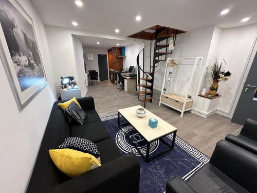 a living room with a black couch and a table at City Canal, Open Space, Spotless, 2 Levels, 4pp, free parking, 5G WiFi in Sheffield