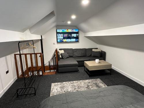 a living room with a couch and a tv at City Canal, Open Space, Spotless, 2 Levels, 4pp, free parking, 5G WiFi in Sheffield