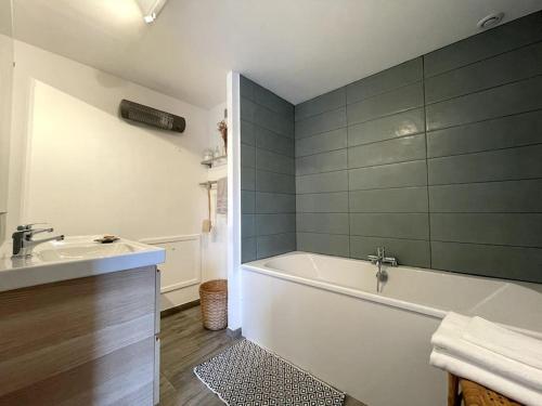 une salle de bain avec une baignoire et un lavabo dans l'établissement l'héberge des Argales, à Vred