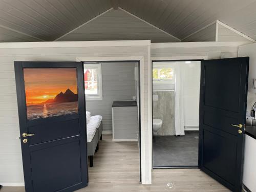 a room with two doors and a bedroom with a bed at Brustranda Fjordcamping in Valberg