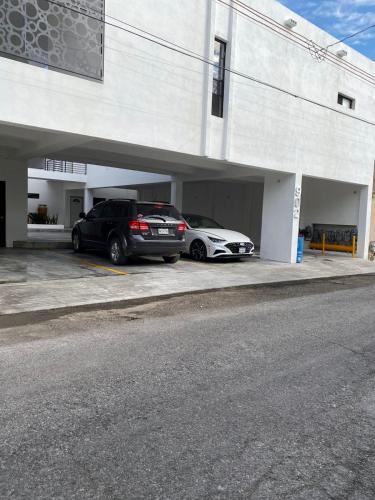 two cars are parked in a parking garage at Departamento moderno cómodo y céntrico in Piedras Negras