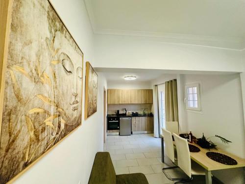 a dining room with a table and a kitchen at Nikos Apartments Corfu in Agios Stefanos