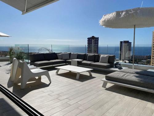 a patio with a couch and a table on a roof at Luxury apartment with stunning terrace and with heated pool in Adeje