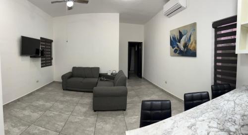 un soggiorno con divano e sedia di Departamento moderno cómodo y céntrico a Piedras Negras