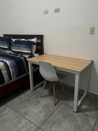 un bureau avec une chaise à côté d'un lit dans l'établissement Departamento moderno cómodo y céntrico, à Piedras Negras