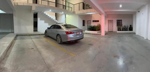 un coche aparcado en un estacionamiento en un edificio en Departamento moderno cómodo y céntrico en Piedras Negras