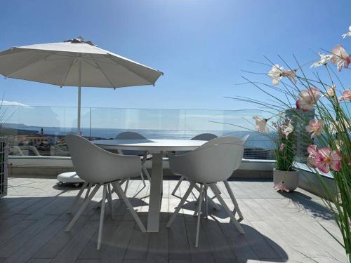 a table and chairs with an umbrella on a balcony at Luxury apartment with stunning terrace and with heated pool in Adeje