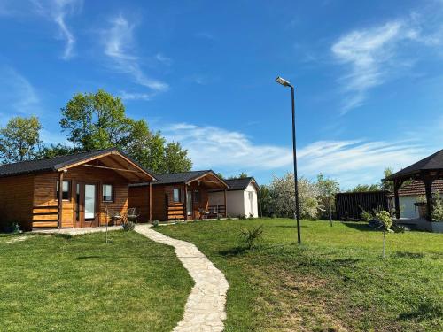 a log cabin with a pathway leading to a house at Horizonti Miroc in Donji Milanovac