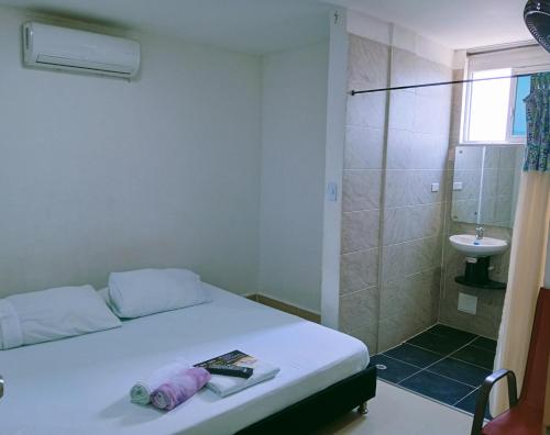 a bedroom with a bed and a shower and a sink at Hostal Martha in Neiva