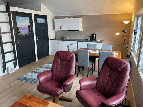 a kitchen and dining room with a table and chairs at Brustranda Fjordcamping in Valberg