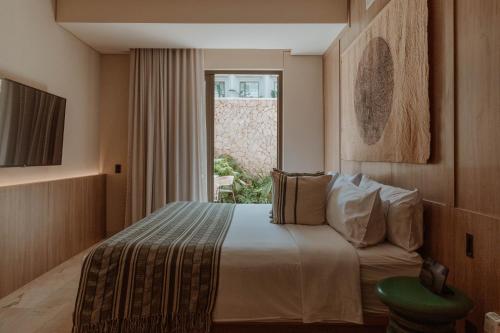 a hotel room with a bed and a window at Osh Hotel Getsemani in Cartagena de Indias