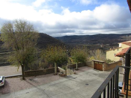 a balcony of a house with a view of mountains at Hostal Paquita in Allepuz