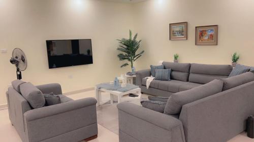 a living room with couches and a flat screen tv at G Guest House in Amman