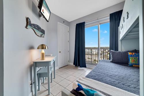 a bedroom with a bed and a desk and a window at Island Royale 701 in Gulf Shores