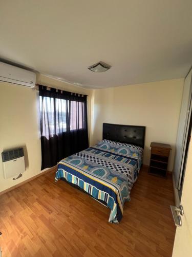 um pequeno quarto com uma cama e uma janela em Relax Haedo norte em Villa Sarmiento