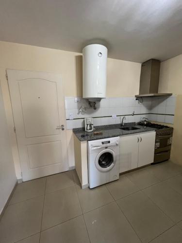 a kitchen with a washing machine and a white door at Relax Haedo norte in Villa Sarmiento