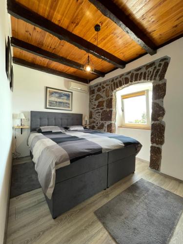a bedroom with a large bed and a brick wall at Apartment Massimo in Rijeka