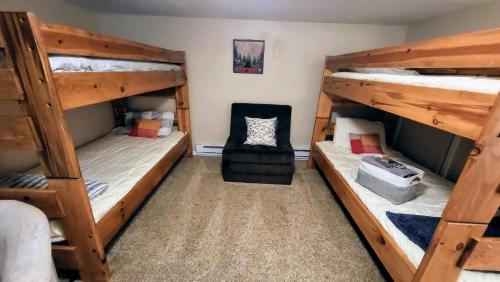 a room with three bunk beds and a chair at Slope Lodge by AvantStay Prime Location PoolHot Tub Access Deck in Crescent Lake