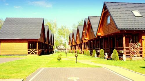 a row of wooden buildings in a park at Ferienhaus in Bobolin mit Terrasse, Garten und Grill in Bobolin