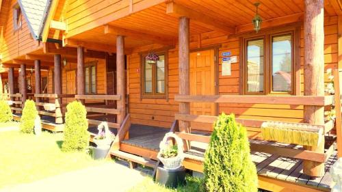 a log cabin with a porch and benches on it at Ferienhaus in Bobolin mit Terrasse, Garten und Grill in Bobolin