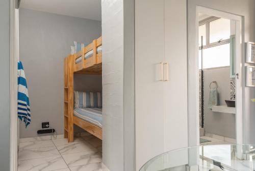 a bedroom with a bunk bed and a mirror at Trendy @ La Ballito 503 in Ballito