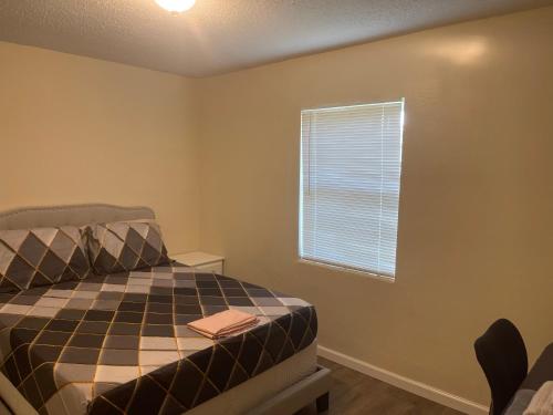 a bedroom with a bed and a window at Private Queen Bedroom C shared common spaces in Fort Pierce