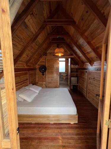 ein Schlafzimmer mit einem Bett in einem Holzzimmer in der Unterkunft Ecolodge Los Pinos in Calima