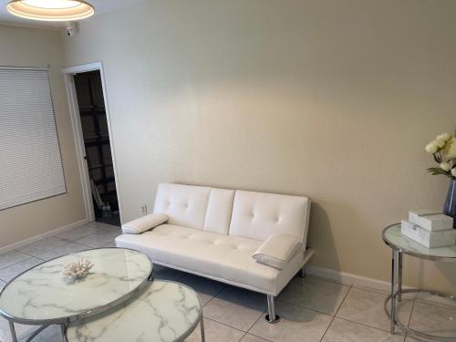 a living room with a white couch and two tables at Private Queen Bedroom C shared common spaces in Fort Pierce