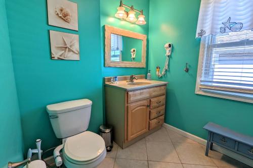 a bathroom with a toilet and a sink and a mirror at Waves n Wooder by AvantStay SwimSpa Game Room Walk to Beach in Wildwood