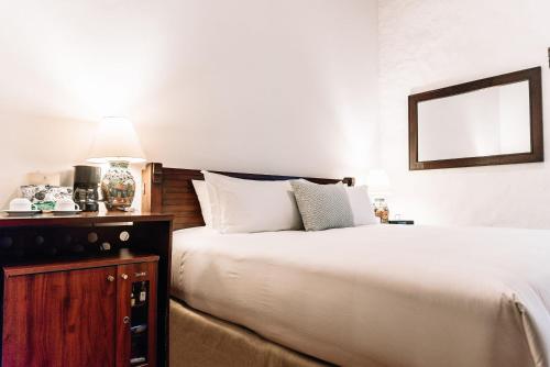 a bedroom with a large white bed and a mirror at Quinta Real Oaxaca in Oaxaca City
