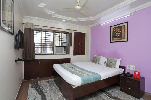 a bedroom with a large bed with purple walls at OYO Hotel Bliss Executive Near Sant Tukaram Nagar Metro Station in Chinchwad