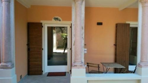 uma porta para uma casa com uma mesa e um banco em Schönes Appartement in Toscolano Maderno mit Terrasse und Garten em Toscolano Maderno