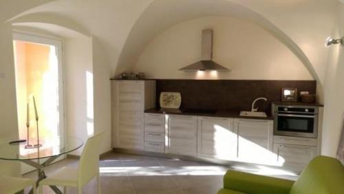 uma cozinha com uma mesa de vidro num quarto em Schönes Appartement in Toscolano Maderno mit Terrasse und Garten em Toscolano Maderno