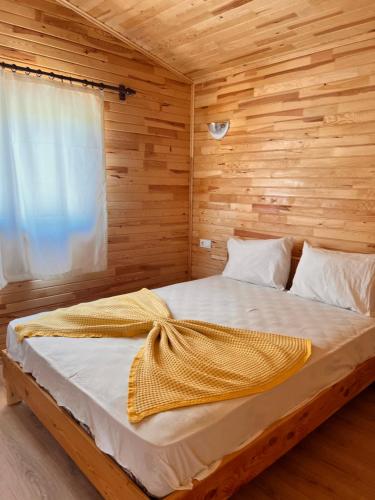 ein Schlafzimmer mit einem Bett mit einer Holzwand in der Unterkunft Adrasan Parlak Apart in Adrasan