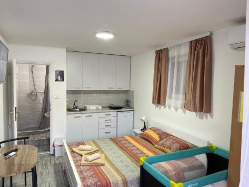 a small bedroom with a bed and a kitchen at Apartmani Kalea in Soko Banja